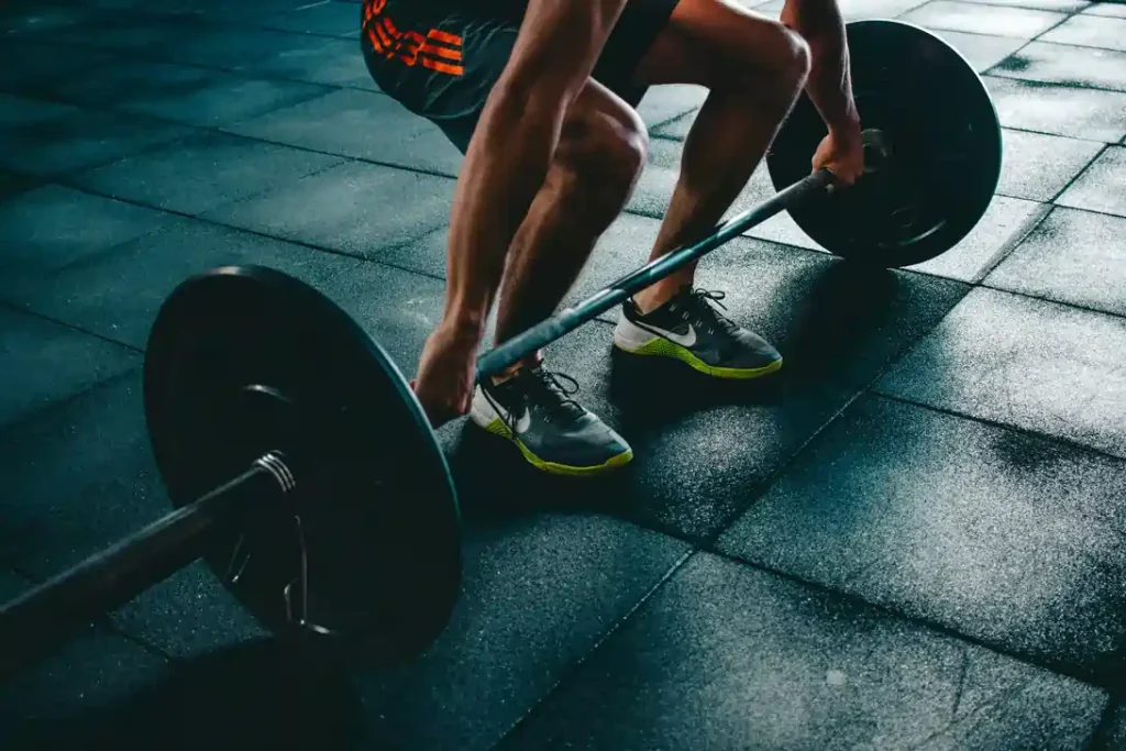 Person lifting a barbell at the gym, representing fitness and supplementary health insurance benefits