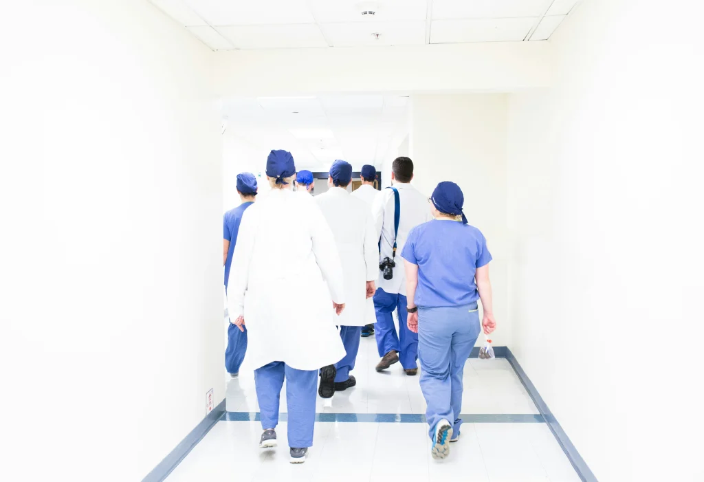 Un grupo de profesionales de la salud caminando por un pasillo de hospital, simbolizando el sistema médico asociado al seguro complementario en Suiza.